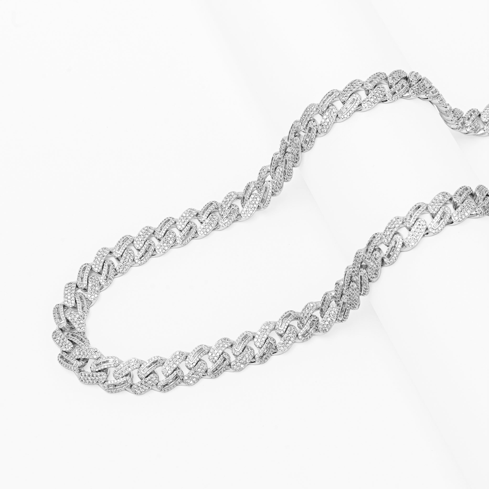 Two iced out silver Cuban chains displayed side by side