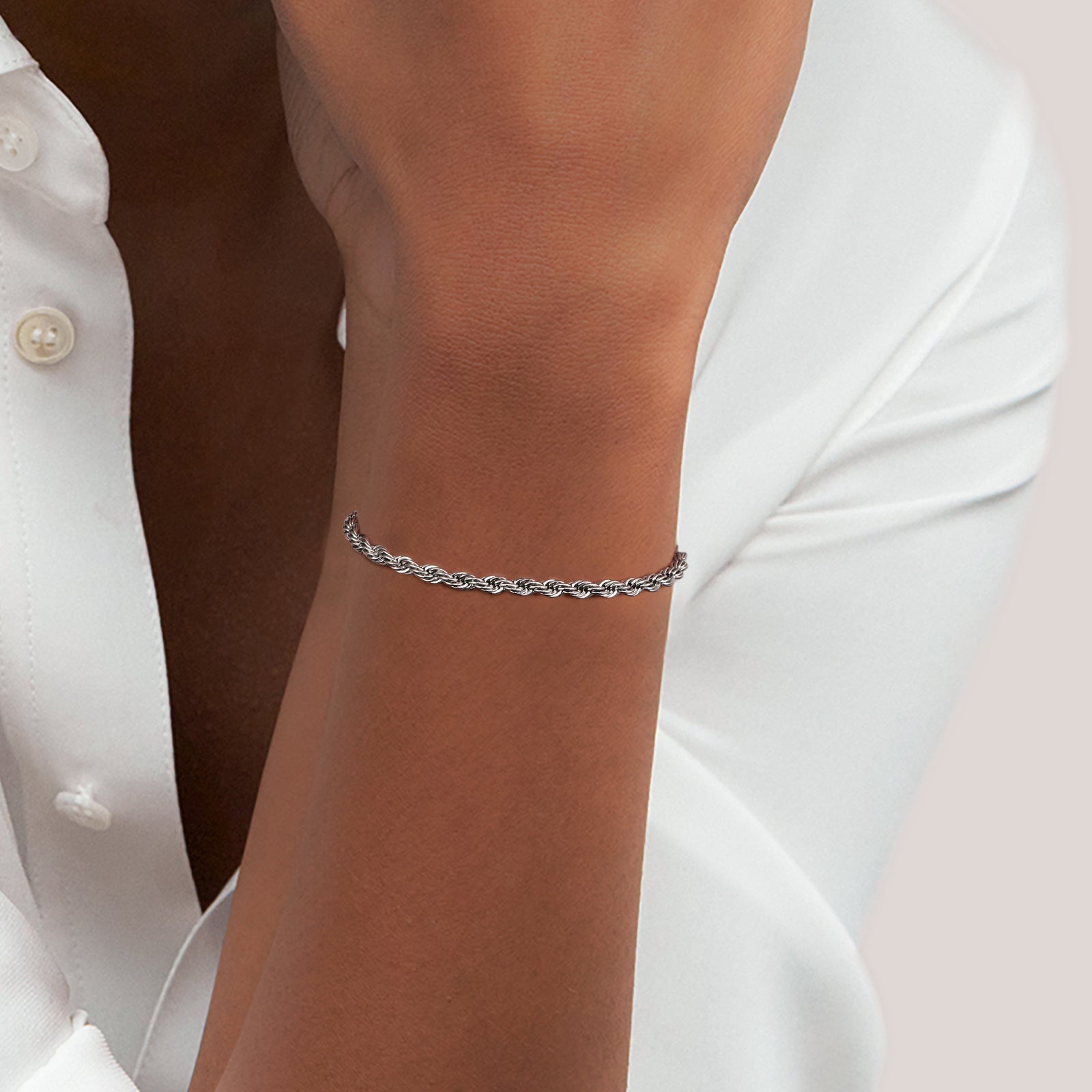Silver rope chain bracelet worn on wrist with twisted link detail