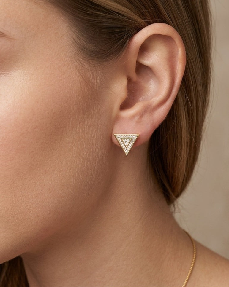 Gold triangle diamond stud earring worn on earlobe, showing size and sparkle