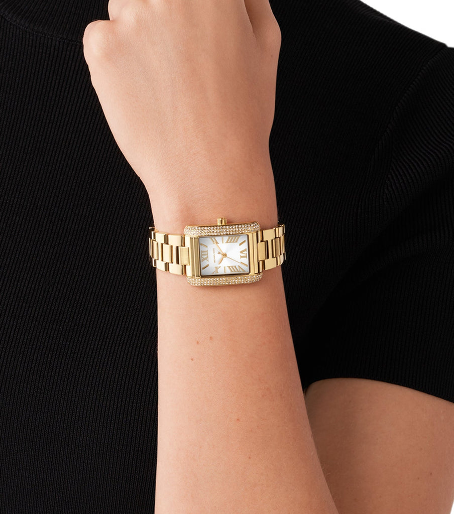 Michael Kors Emery rectangular gold watch worn on wrist with white dial
