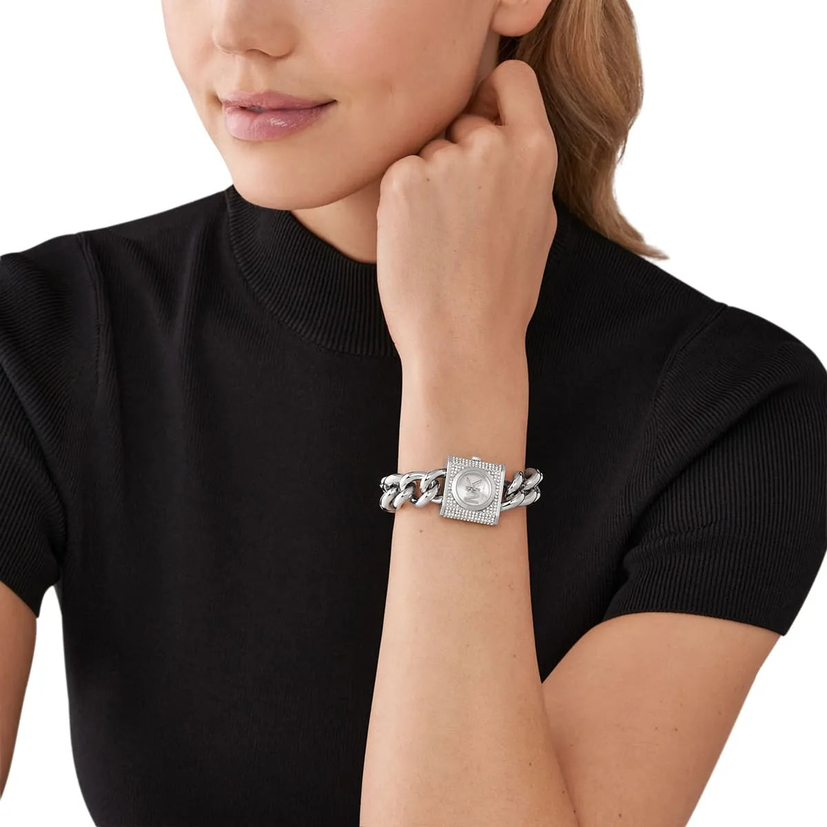 Michael Kors Mini Lock watch on women's wrist showing square crystal pavé case and chain strap