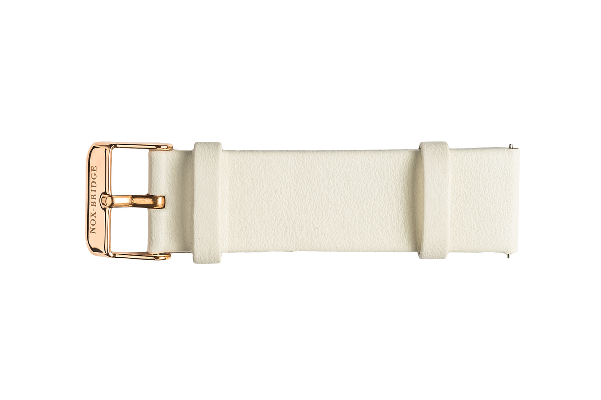 White vegan leather strap with metallic gold buckle and engraved details