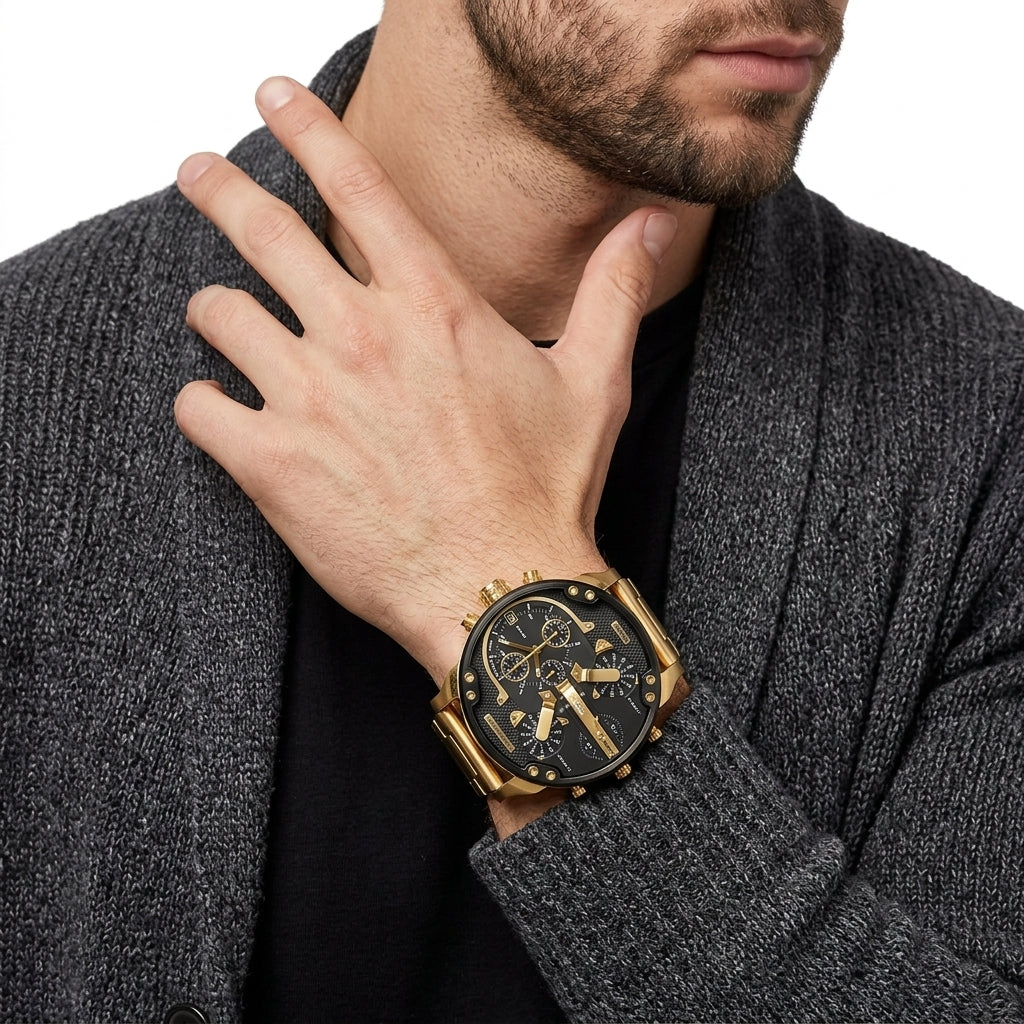 A close-up of a man wearing a gold-tone chronograph watch with a black dial and gold bracelet, styled with a dark gray knit cardigan over a black shirt.