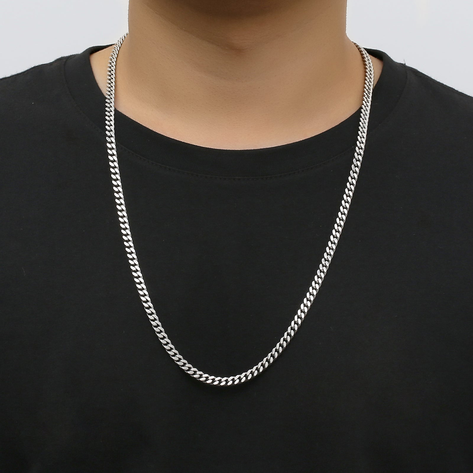 5mm Cuban silver chain worn around neck on model in black shirt