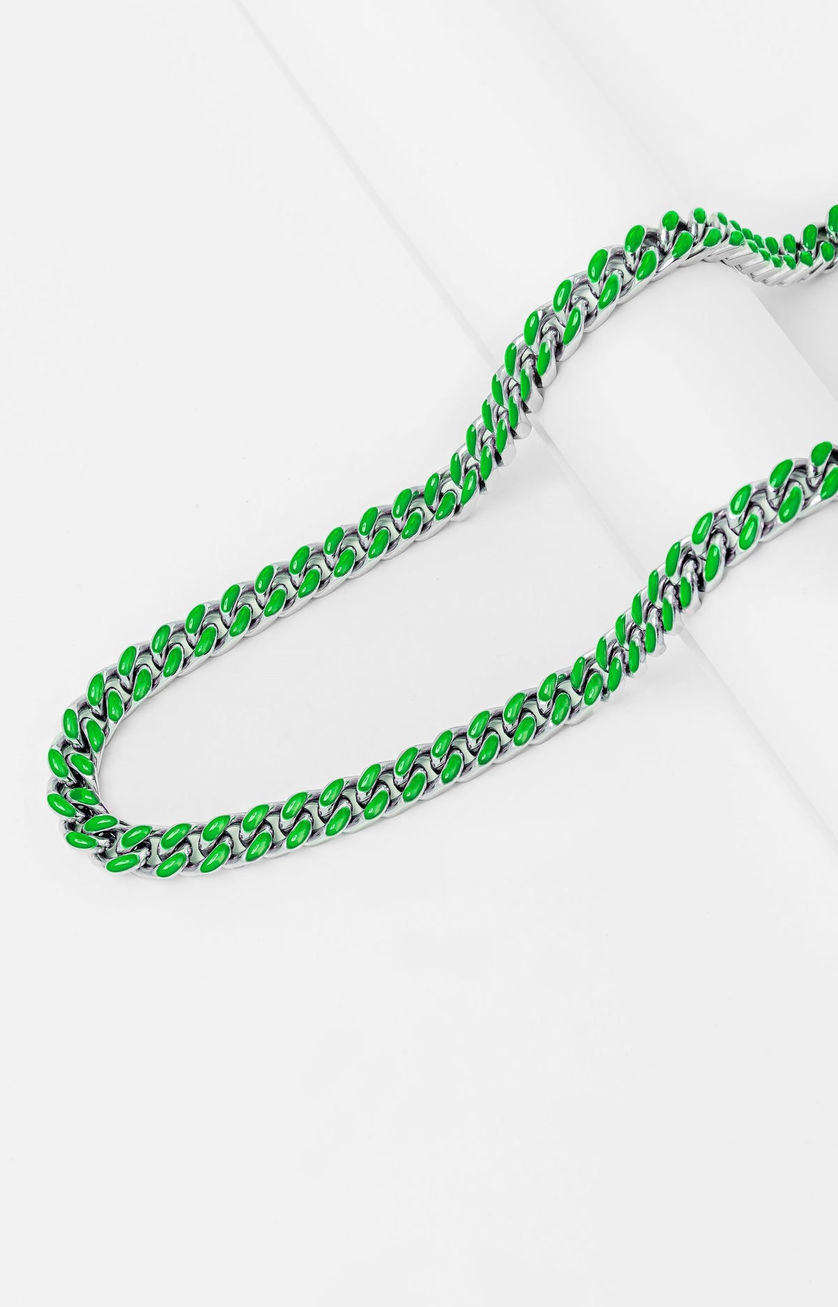 Green and silver Cuban chain links shown in curved formation, side view
