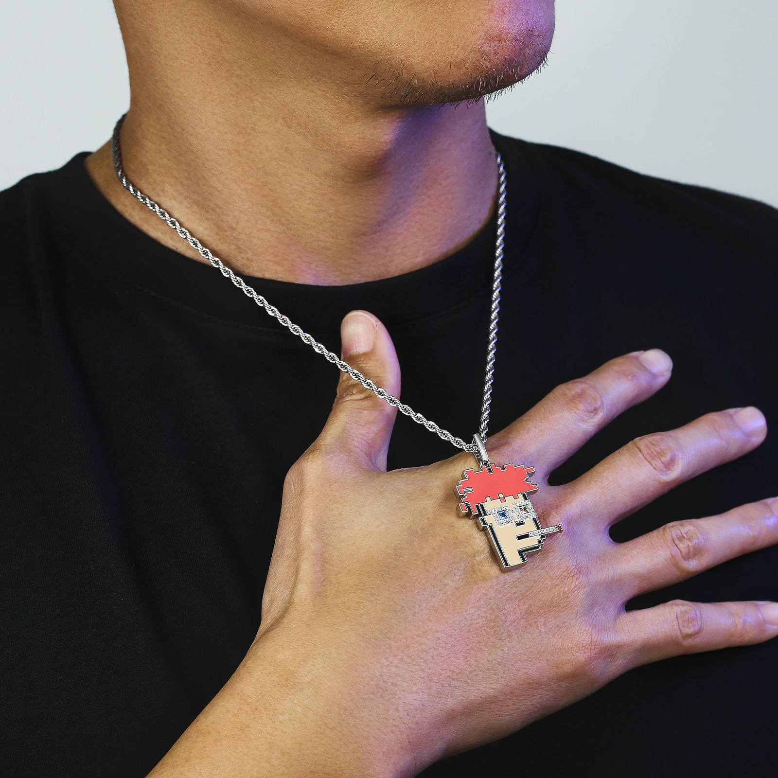 Close-up of Big Daddy Cryptopunk pendant held in hand showing iced-out crystal and red pixelated design