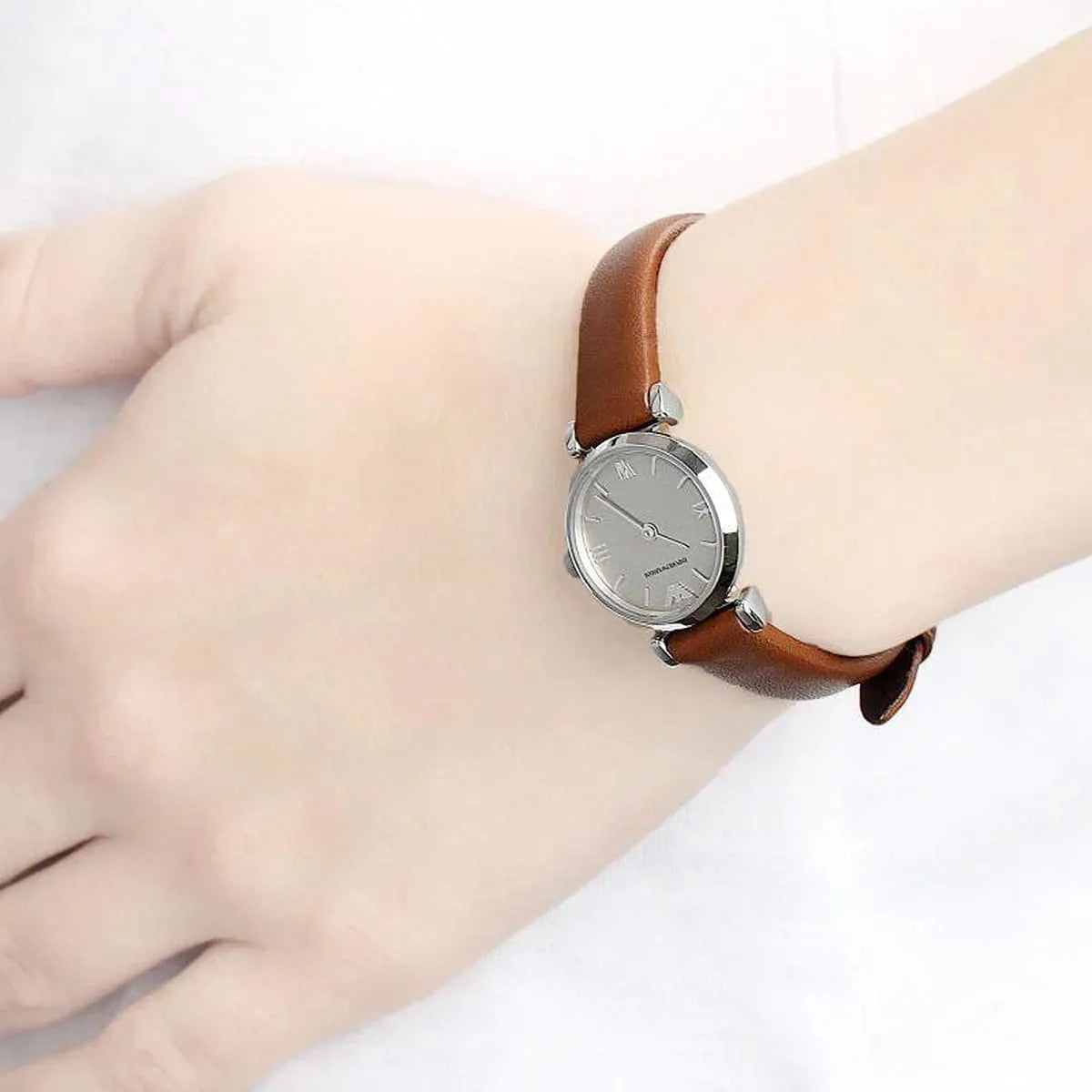 Emporio Armani Gianni T-Bar mini silver watch worn on wrist with brown leather strap