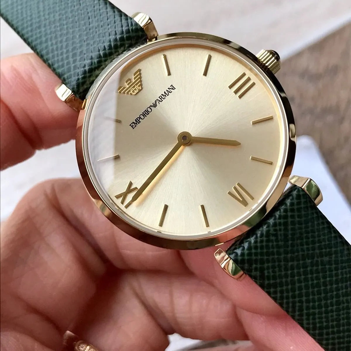 Close-up of Emporio Armani Gianni AR1726 cream dial with gold Roman numerals and hands