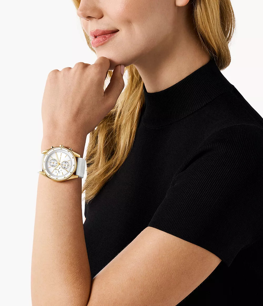 Michael Kors Hadyn MK7484 gold chronograph watch worn on wrist with white strap