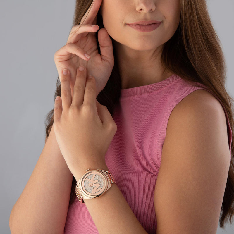 Michael Kors Janelle rose gold-tone watch worn on wrist by woman