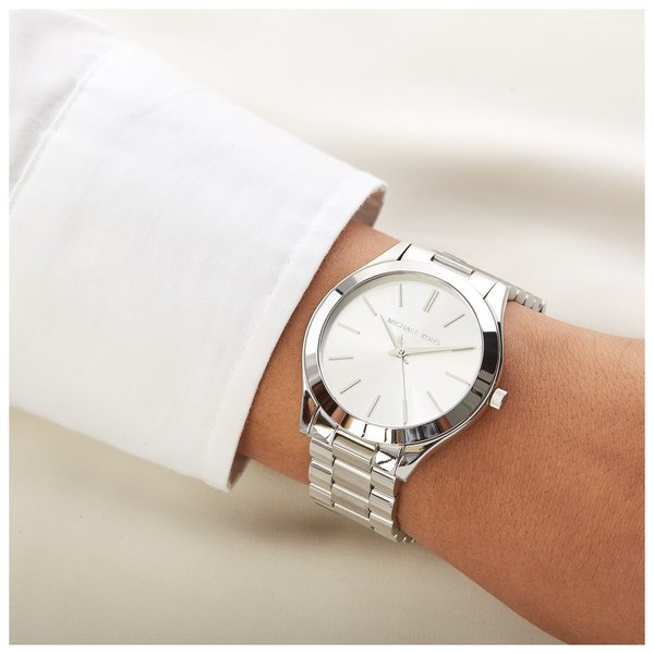 Michael Kors Runway silver watch worn with white sleeve on wrist