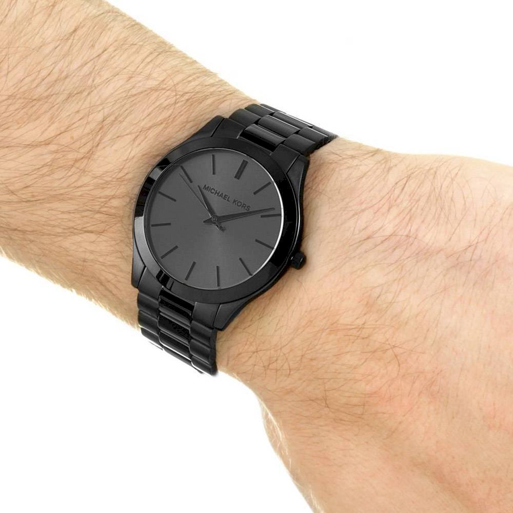 Michael Kors Slim Runway watch on men's wrist showing dial and black-tone bracelet