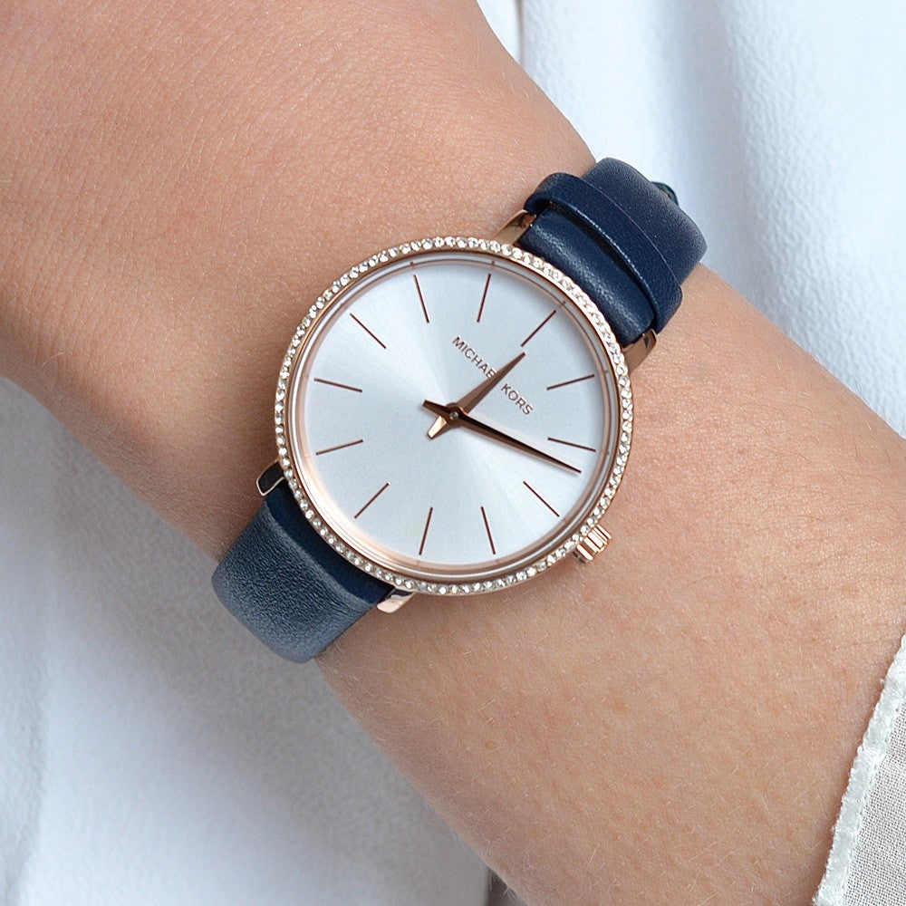 Michael Kors Pyper watch worn on wrist showing white dial with rose gold hands and indices