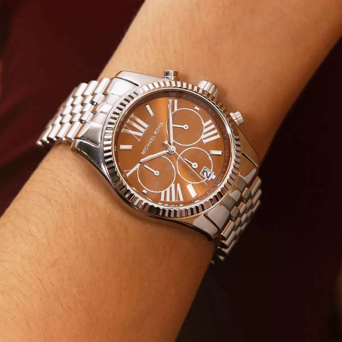 Michael Kors Lexington MK6221 chronograph watch with orange dial worn on wrist
