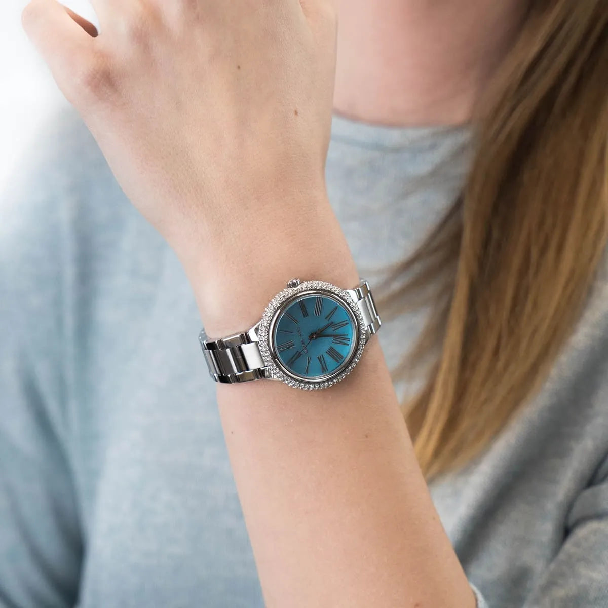 Michael Kors Mini Taryn blue dial watch styled on wrist with silver bracelet
