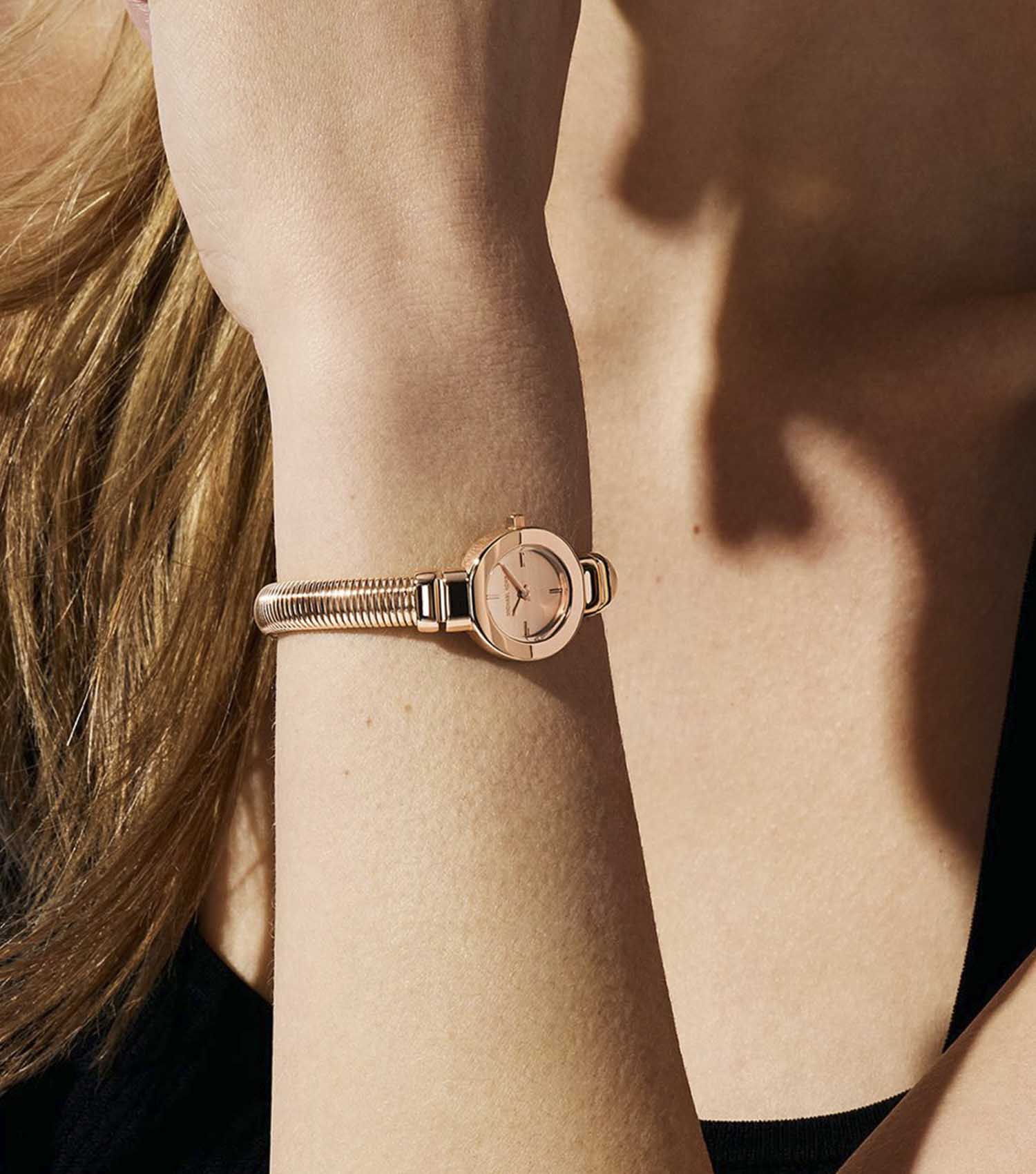 Michael Kors Mini Gramercy rose gold watch worn on wrist with textured bangle bracelet