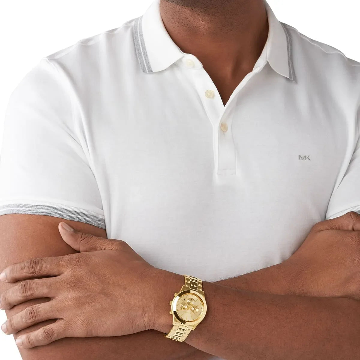 Michael Kors MK8909 gold chronograph watch worn on wrist with white polo shirt