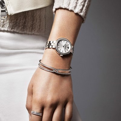 Woman wearing Swarovski Octea Sport watch with stainless steel bracelet and accessories