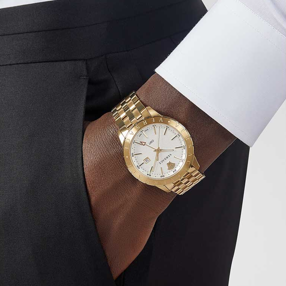 Versace Univers gold watch worn on wrist with white dial and gold steel band