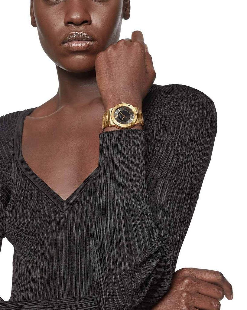 Versace Greca gold watch worn on wrist, black dial and Medusa bezel detail