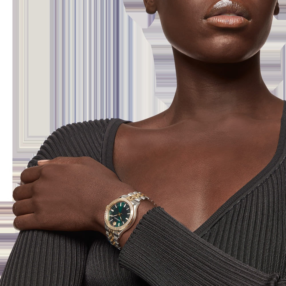 Versace Hellenyium women's watch worn on wrist, showing green dial and two-tone steel strap