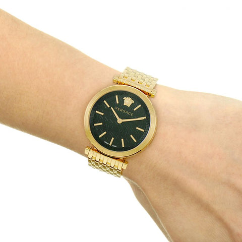 Versace V-Twist watch worn on wrist showing black dial and gold mesh bracelet